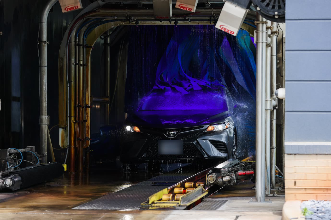 A car moving through the Zoom Express tunnel under purple-lit wash curtains
